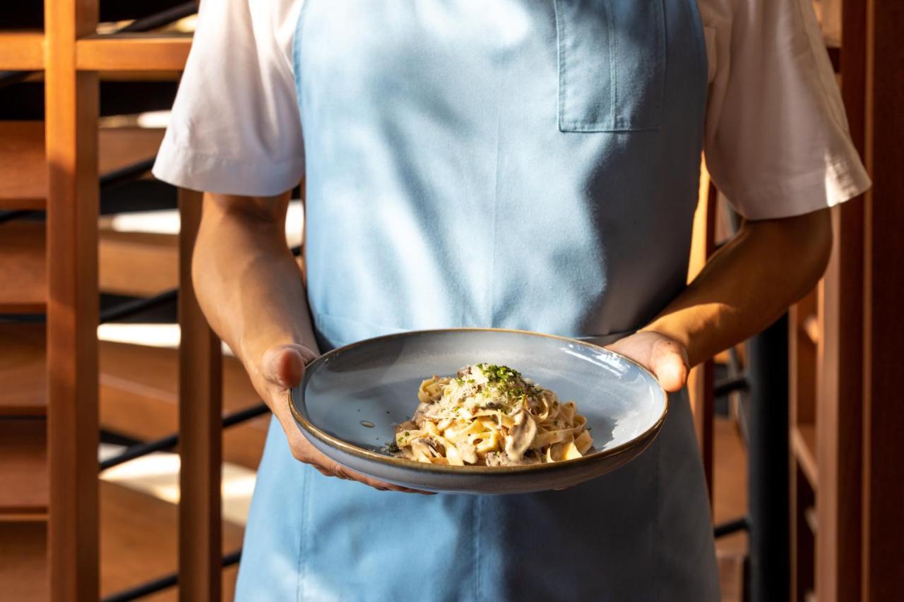 Outrigger Surin Beach Resort - Sha Extra Plus 외부 사진 A server holding a plate of pasta